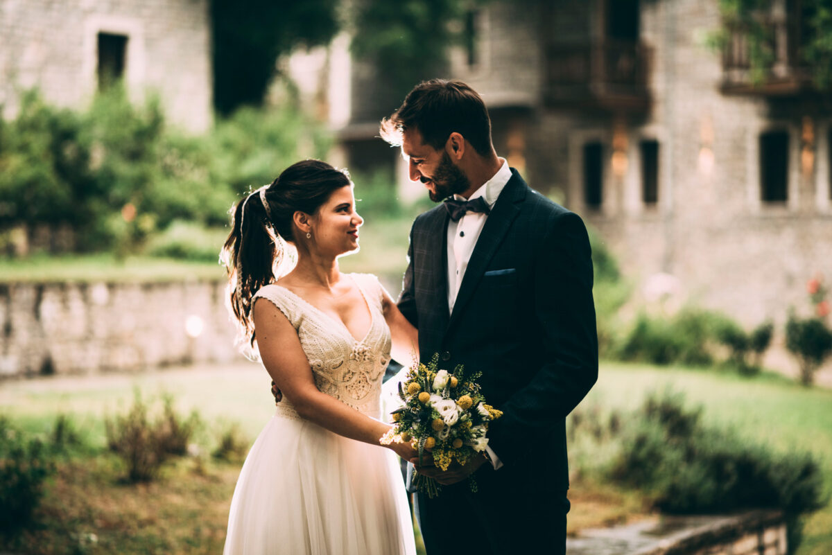 Bride and groom during their wedding in Pertouli, Trikala, with a stunning rustic mansion in the background.